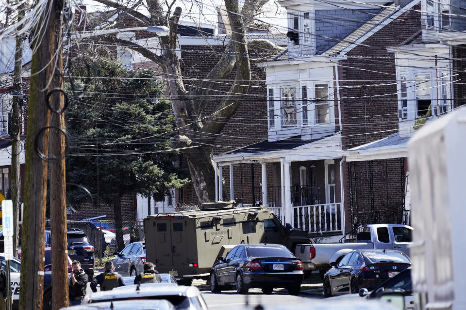 Police surround a home in Trenton, N.J., Saturday, March 16, 2024. A suspect has barricaded himself in the home and was holding hostages after shooting three people to death in suburban Philadelphia. (AP Photo/Matt Rourke)