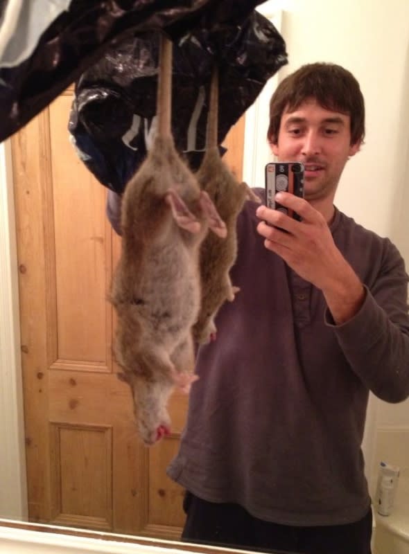 Adrian Whitaker holding the rat he caught and killed.