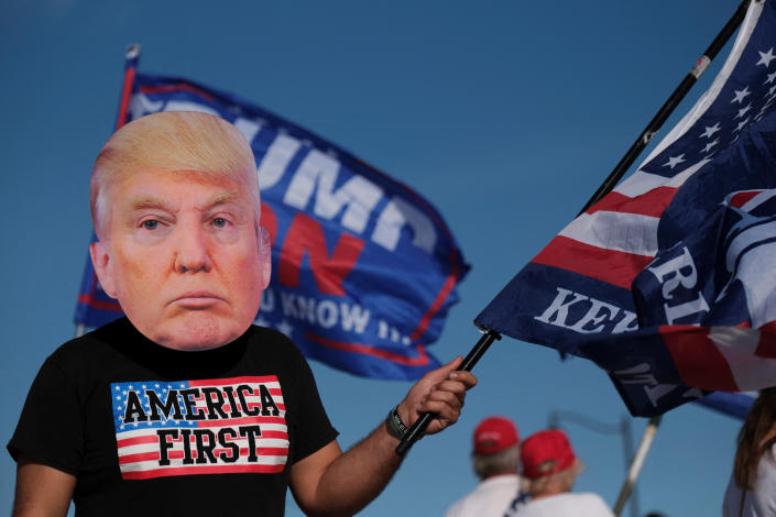 A Trump supporter in a T-shirt marked America First demonstrates outside Mar-a-Lago in Palm Beach, Fla.