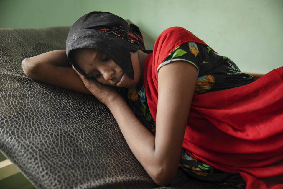 In this July 26, 2019 photo, Fadya Mohammed, a migrant from Ethiopia, lays on a gurney after disembarking from a boat and feeling sick from the sea, at the Ras al-Ara Hospital, Lahj, Yemen. In Djibouti, her and her sister were held by traffickers, who beat them and ordered them to ask their parents to send money for their release. The parents had to borrow money from neighbors to secure their daughter's release. (AP Photo/Nariman El-Mofty)