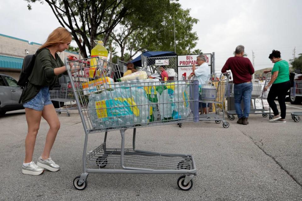 A shopper walks to her vehicle with a cart full of bottled water at BJ’s Wholesale Club in preparation for Hurricane Dorian, Thursday, Aug. 29, 2019, in Hialeah, Fla. Hurricane Dorian is heading towards Florida for a possible direct hit on the state over Labor Day. (AP Photo/Lynne Sladky)