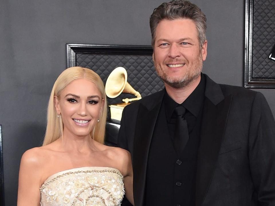 Gwen Stefani wearing a white dress and Blake Shelton wearing a black suit at the 2020 Grammys.