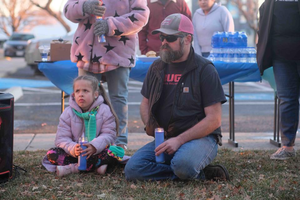 Matthew Thomson and daughter Scout sit with their lit candles  Thursday at the Lights to End Human Trafficking Event in Amarillo.