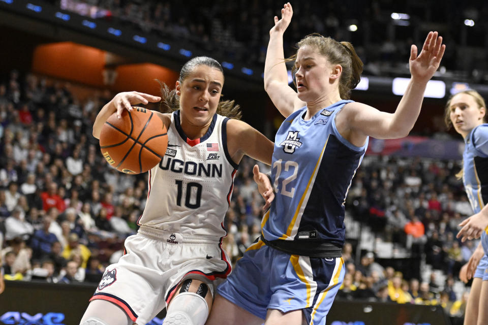 UConn's Nika Muhl (10) drives to the basket as Marquette's Mackenzie Hare (12) defends during the second half of an NCAA college basketball game in the semifinals of the Big East Conference tournament at Mohegan Sun Arena, Sunday, March 5, 2023, in Uncasville, Conn. (AP Photo/Jessica Hill)