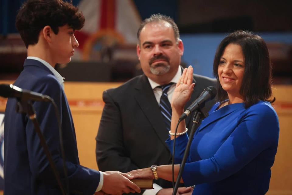 Maria Bosque-Blanco, newly appointed Miami-Dade School Board member, right, gets sworn in with the help of her son, Richie, left, and the support of her husband, Richard Blanco Jr., on Wednesday, Jan. 18, 2023, in downtown Miami.