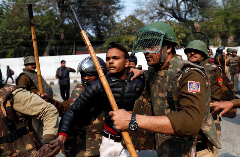 Police detain an unidentified man after he brandished a gun and injured a student during a protest against a new citizenship law outside the Jamia Millia Islamia university in New Delhi