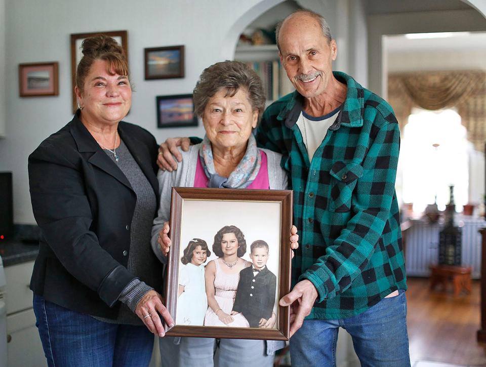 Braintree mother June Newman with her children Linda Sylvester and Robert Newman on Friday April 29, 2022. The photograph she is holding was taken in 1964 when Linda was seven and Bob was five.