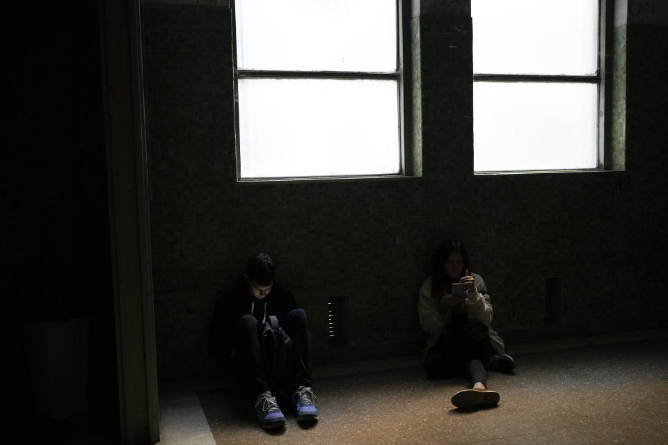 Estudiantes de la Universidad de Buenos Aires (UBA) esperan en un pasillo a oscuras en el edificio de Medicina antes de entrar a clase en Buenos Aires, Argentina, el jueves 18 de abril de 2024. Las autoridades universitarias apagaron las luces para ahorrar electricidad tras las medidas de austeridad dispuestas por el presidente argentino, Javier Milei, que incluye un congelamiento del presupuesto de la UBA. (AP Foto/Natacha Pisarenko)