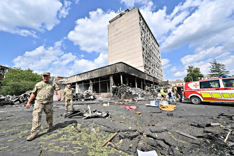 Ukrainian army members and firefighters inspect a damaged building following a Russian airstrike in the city of Vinnytsia, west-central Ukraine on July 14, 2022. - At least 20 people were killed Thursday by Russian strikes on a city in central Ukraine, bombings described as "an openly terrorist act" by Ukrainian President Volodymyr Zelensky. (Photo by Sergei SUPINSKY / AFP)