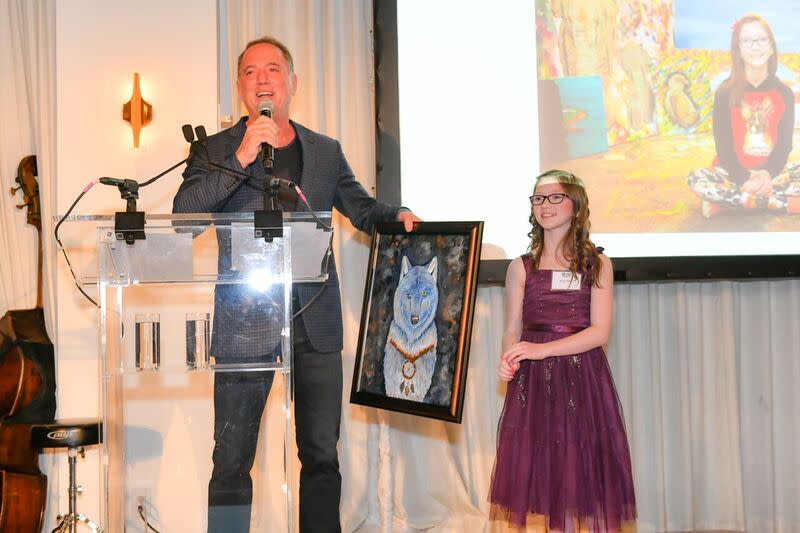 Jefferies CEO Rich Handler auctions off a painting from Bria Neff, an 11-year-old artist dedicated to saving endangered animals, during a fundraiser for the Wolf Conservation Center in New York.