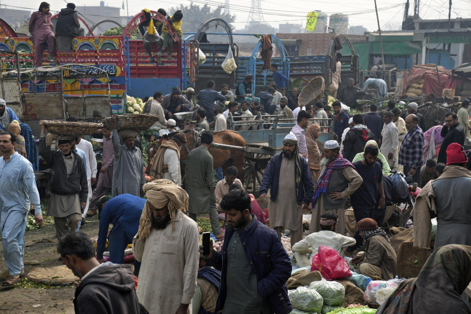 Laborers work at a wholesale vegetable and fruit market in Lahore, Pakistan, Friday, Feb. 17, 2023. Many laborers are worried how they will survive after the government advanced a bill to raise 170 billion rupees in tax revenue. That could worsen impoverished Pakistan's economic outlook as it struggles to recover from devastating summer floods and a wave of violence. (AP Photo/K.M. Chaudary)