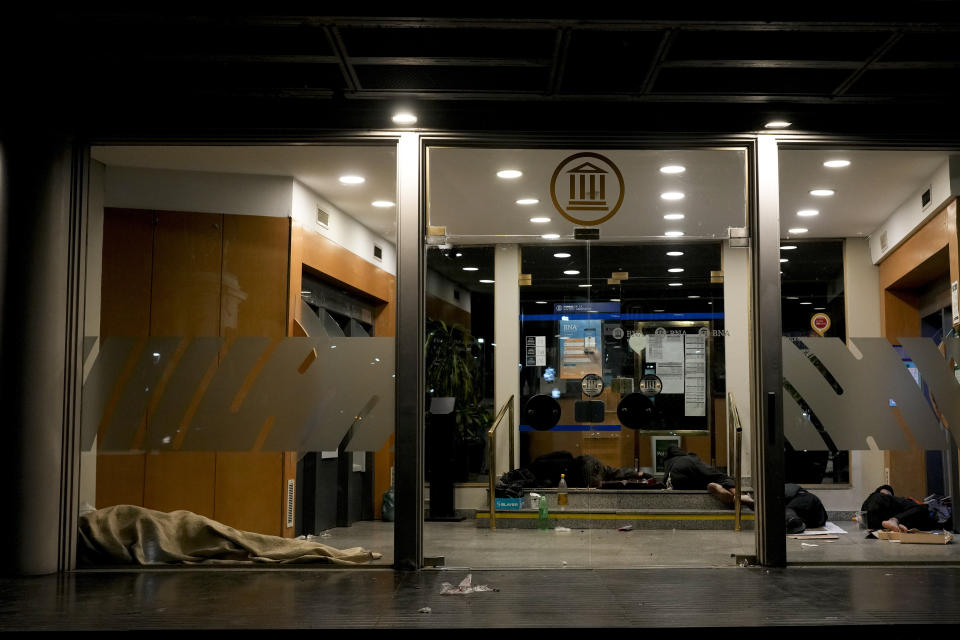 Personas en condición de calle duermen dentro del cajero de un banco en Buenos Aires, Argentina, el miércoles 27 de septiembre de 2023. (AP Foto/Natacha Pisarenko)