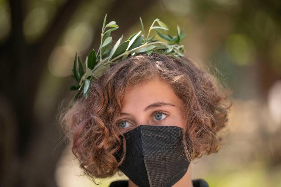 Liz Brehler, 14, of Davis, wears an olive tree branch as a headdress as she learns how to propagate an olive tree from cuttings on Friday at the UC Davis Olive Center. Students learned how to cook with olive oil and how to grow their own olive tree.