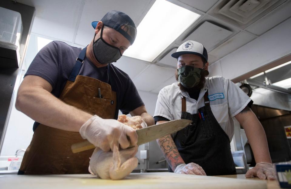 Kevin Grossi shows Patrick Romsa how to cut up a chicken at The Regional in Fort Collins in this file photo.