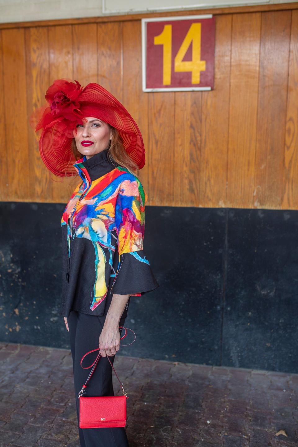 Model Hope Daniels wears a red horsehair Frank Olive hat ($368), floral print on black Damee jacket ($168 ) and red Michael Kors tiny bag ($128) all from Von Maur during a Kentucky Derby fashion shoot with stylist Jo Ross at Churchill Downs. March 28, 2019