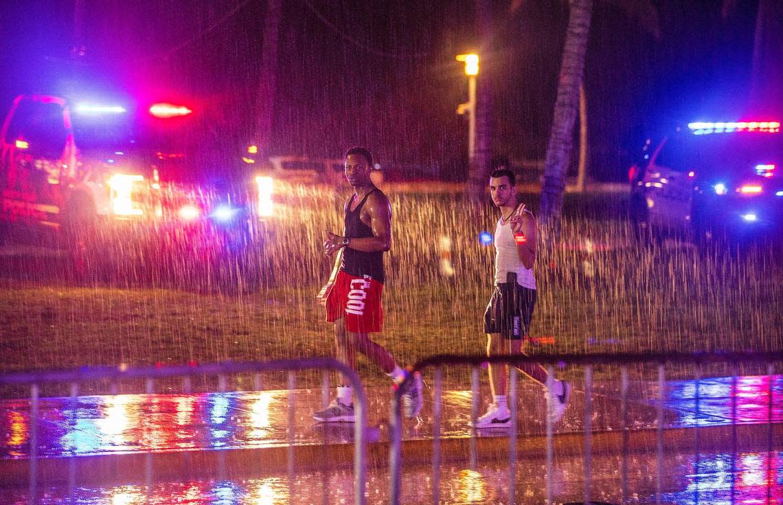 Spring breakers walk under the rain as it downpours on Ocean Drive, during spring break in Miami Beach, on Saturday March 16, 2024.