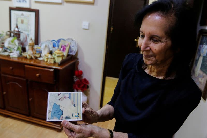 FILE PHOTO: Najla Uchi shows a photo of Pope Francis hugging a Muslim scholar during an interview with her at her home in Manama
