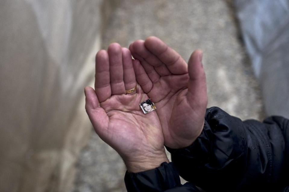 In this Tuesday, Jan. 24, 2017 photo, Rustum Abdulrahman, 35, a Syrian refugee from the northern district of Al-Ashrafiya, Aleppo, shows a photograph of his wife Zuzan, 33, at Ritsona refugee camp, Greece. "I keep this image always with me, I made it as small as possible so no matter what it won't be damaged and will never loose it, my wife is my best friend and the partner of my life." Rustum said. (AP Photo/Muhammed Muheisen)