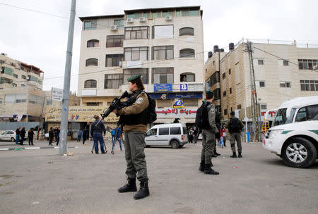 Israeli border police officers stand guard outside the building where Israeli security officers closed a Palestinian map office complying with an Israeli police order to close the office, in the Arab East Jerusalem neighbourhood of Beit Hanina March 14, 2017. REUTERS/Ammar Awad