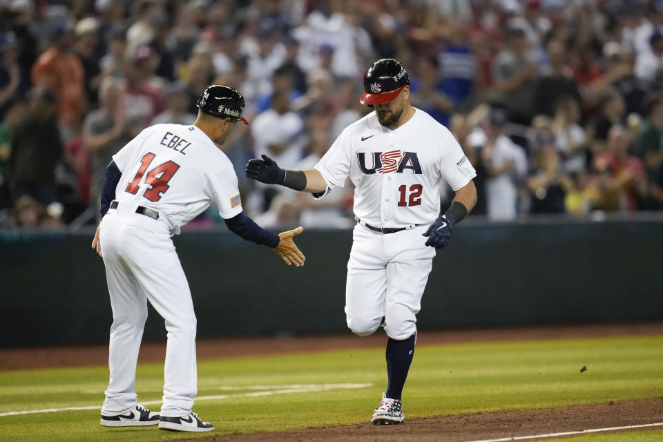 United States' Kyle Schwarber, right, celebrates with third base coach Dino Ebel after hitting a three-run home run against Great Britain during the fourth inning of a World Baseball Classic game in Phoenix, Saturday, March 11, 2023. (AP Photo/Godofredo A. Vásquez)
