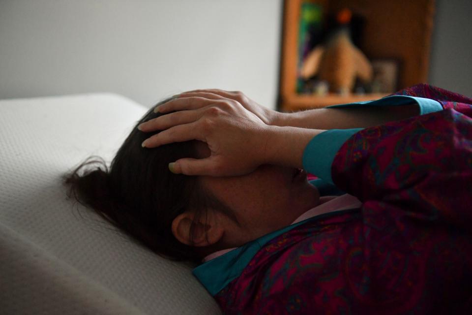 Rebecca Schleider, 41, lays down on her bed, Thursday, April 27, 2023, in Stuart, Fla. Schleider has lived with long COVID since contracting the virus during the first wave in 2020. "If I could be guaranteed that if I got COVID again, I would be fine or die, that would be more comfortable for me," Schleider said. "But what I can't handle is the torture of just having to sit there and exist ... it is horrible." Her ailments include chronic fatigue, postural orthostatic tachycardia syndrome, known as POTS, and extreme exertion malaise.