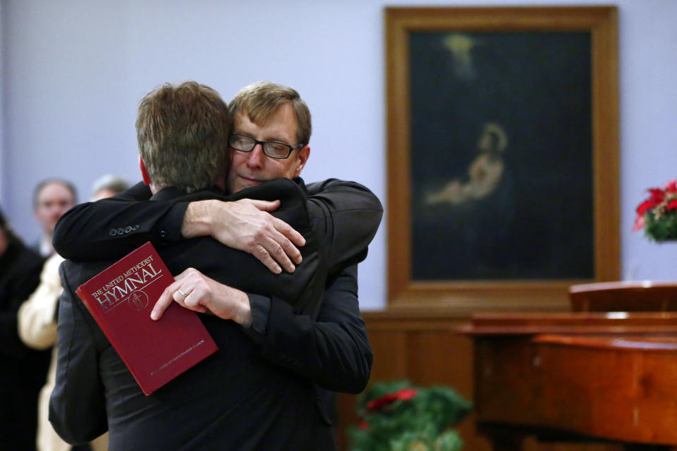 FILE - In this Monday, Dec. 16, 2013 file photo, the Rev. Robin Hynicka, right, embraces the Rev. Frank Schaefer, a United Methodist clergyman convicted of breaking church law for officiating at his son's same-sex wedding, during a news conference at the Arch Street United Methodist Church in Philadelphia. Schaefer plans to defy a church order to surrender his credentials for performing a same-sex wedding. (AP Photo/Matt Rourke)