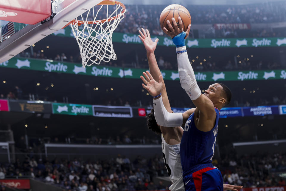 Los Angeles Clippers guard Russell Westbrook, right, scores against Utah Jazz guard Johnny Juzang during the first half of an NBA basketball game Friday, April 5, 2024, in Los Angeles. (AP Photo/Etienne Laurent)