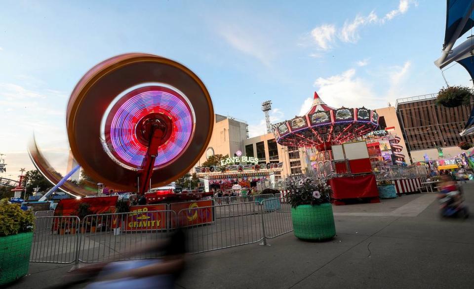 Las luces de las atracciones de la feria comienzan a brillar mientras el sol se pone el día de la inauguración de la Feria Estatal de Texas, el viernes 24 de septiembre de 2021.