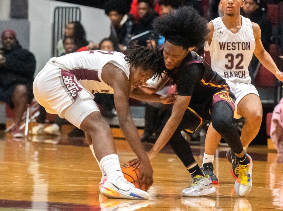 Weston Ranch's Darrion Lilly, left, fights for a loose ball with Edison's Daeleon Neal during a boys varsity basketball game at Weston Ranch in Stockton on Wednesday, Jan. 4, 2023. This is an example of a sports photo.