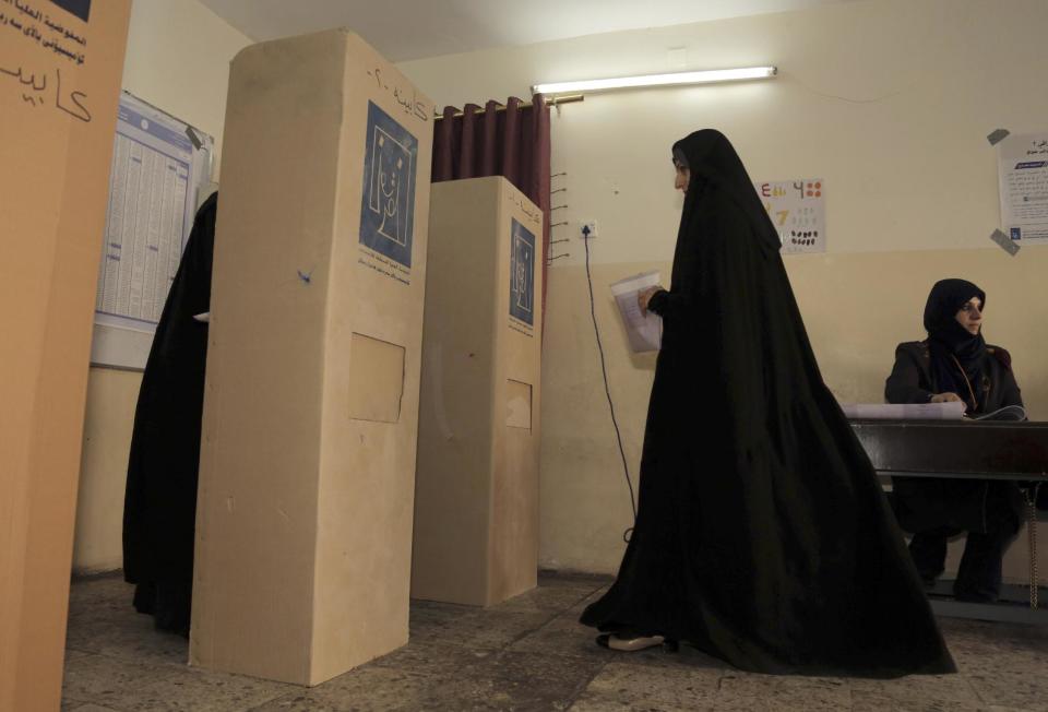 An Iraqi woman prepares to casts her vote at a polling station in Baghdad, Iraq, Wednesday, April 30, 2014. A key election for a new Iraqi parliament was underway on Wednesday amid a massive security operation as the country continued to slide deeper into sectarian violence more than two years after U.S. forces left the country. (AP Photo/ Khalid Mohammed)