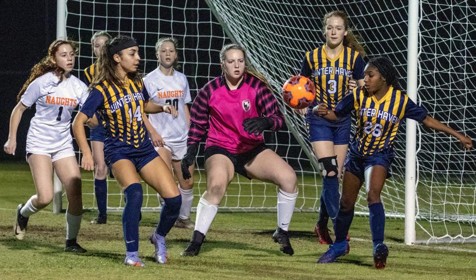 Winter Haven's Jordyn Frasier attempts to clear the ball in front of Winter Haven goalkeeper Delaney Jarrett as Sophia Olivera (1), Lydiana Ferrero (14), Naomi Garner 20, and Isabella McCard (3) follow the action.