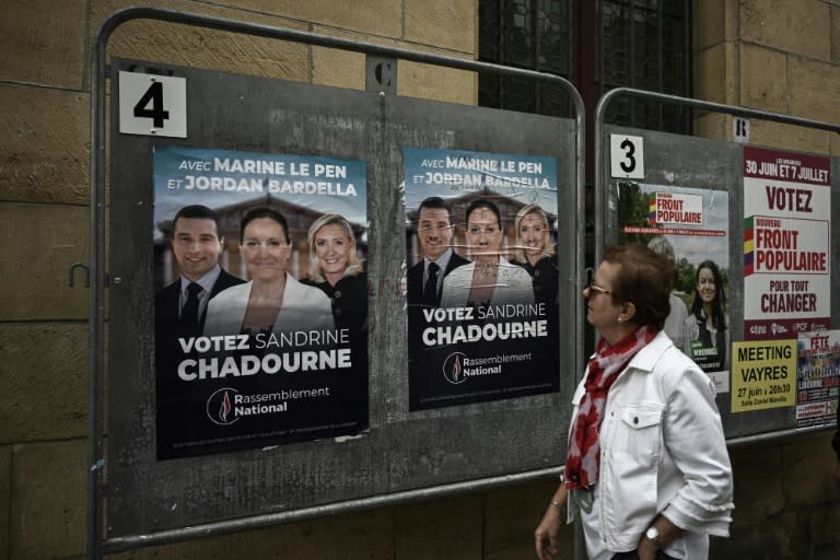 Una mujer pasa frente a unos carteles electorales de los comicios legislativos galos, el 2 de julio de 2024 en Libourne, al suroeste de Francia (Philippe Lopez)