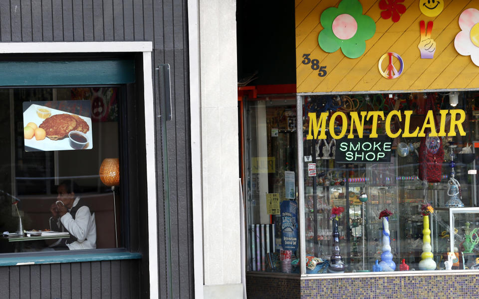 In this photograph taken Thursday, Oct. 18, 2012, in Montclair, N.J., Ben Ali, 66, eats breakfast at a restaurant which is next to a head shop. The opening of New Jersey's first state-authorized medical marijuana dispensary is delayed. The New Jersey Department of Health says that Greenleaf Alternative Treatment Center will not be ready to open for several weeks because it does not have its final certificate of occupancy from Montclair Township. (AP Photo/Julio Cortez)