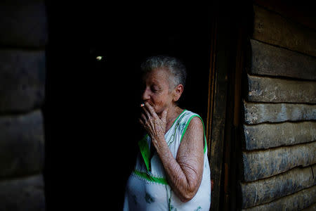 Farmer Irene Fernandez, 65, smokes a cigarette at her home in the village of Cerrito de Naua, in the Sierra Maestra, Cuba, March 30, 2018. REUTERS/Alexandre Meneghini