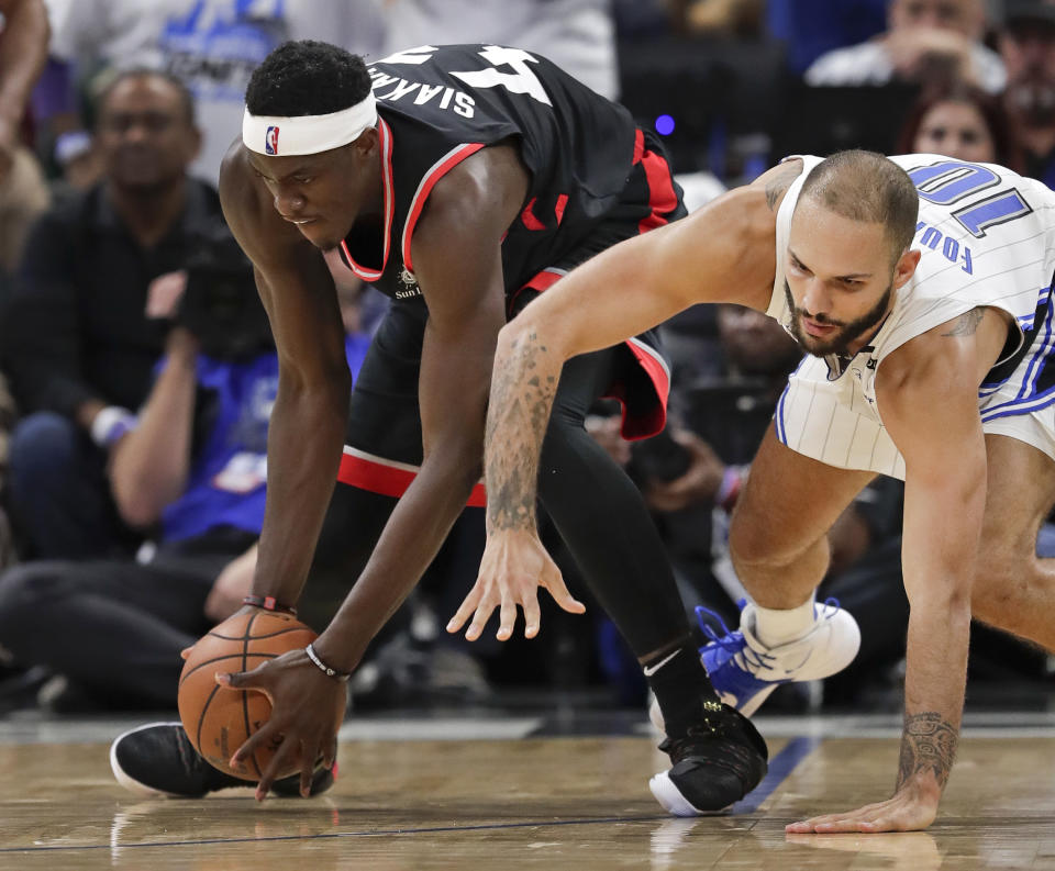 Toronto Raptors' Pascal Siakam, left, grabs the ball in front of Orlando Magic's Evan Fournier during the second half in Game 3 of a first-round NBA basketball playoff series, Friday, April 19, 2019, in Orlando, Fla. (AP Photo/John Raoux)