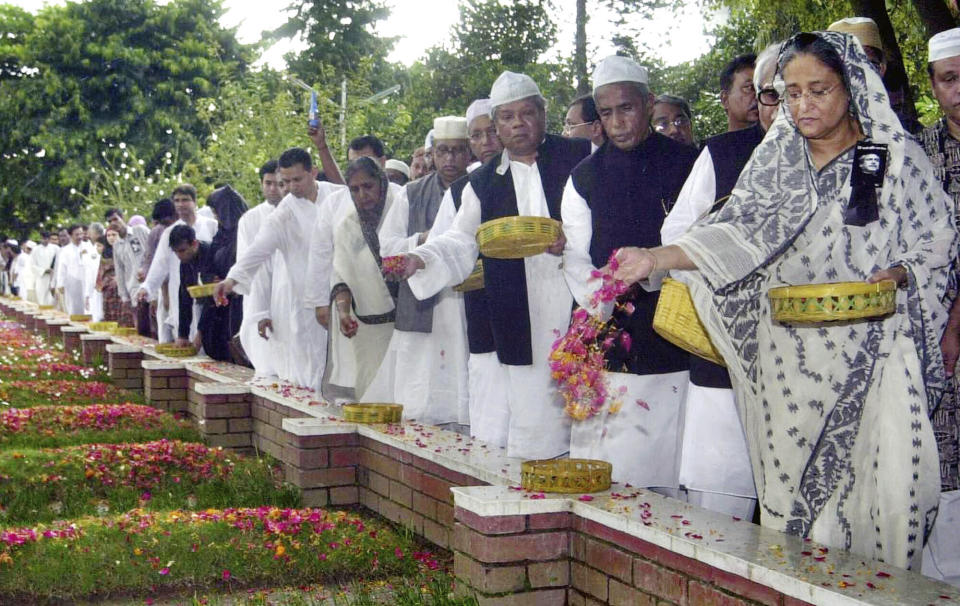 FILE- Sheikh Hasina, right, daughter of Bangladesh's independence leader Sheikh Mujibur Rehman, pays homage at the graves of her 15 family members who were killed in a 1975 military coup, in Dhaka, Bangladesh, Aug. 15, 2005. Prime Minister Hasina's political life was shaped by the Aug. 15, 1975 military coup and assassination of her father, Rahman, the first leader of independent Bangladesh. Some say the brutal takeover, which also killed most of her family, pushed her to consolidate unprecedented power. (AP Photo/Pavel Rahman, File)