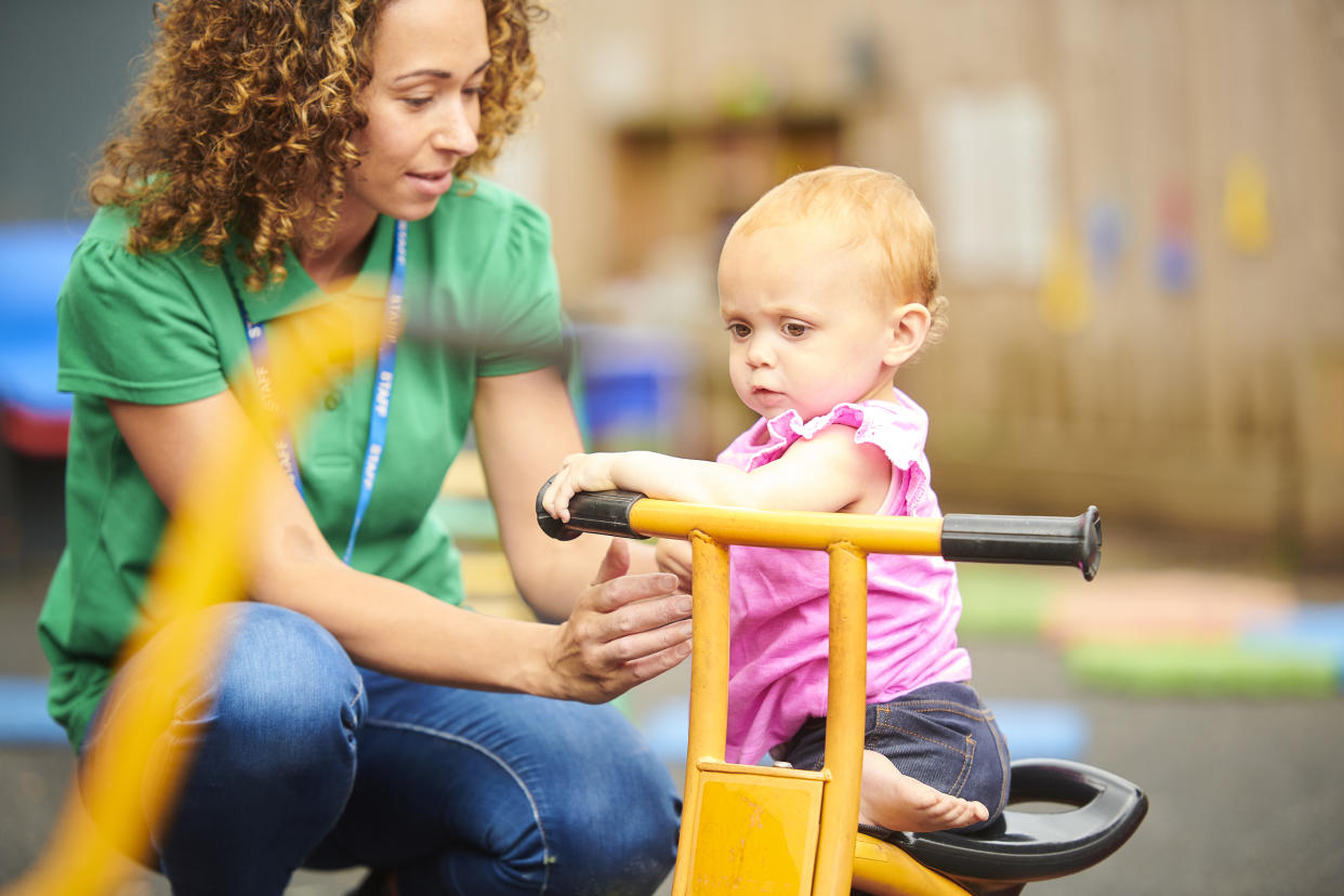 nursery worker with child in playground