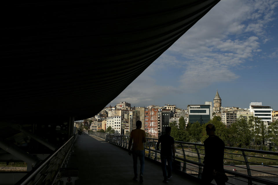 People walk on an underpass of the Galata Bridge over the Golden Horn in Istanbul, Friday, May 14, 2021.Turkey is in the final days of a full coronavirus lockdown and the government has ordered people to stay home and businesses to close amid a huge surge in new daily infections. But millions of workers are exempt and so are foreign tourists. Turkey is courting international tourists during an economic downturn and needs the foreign currencies that tourism brings to help the economy as the Turkish lira continues to sink. (AP Photo/Emrah Gurel)