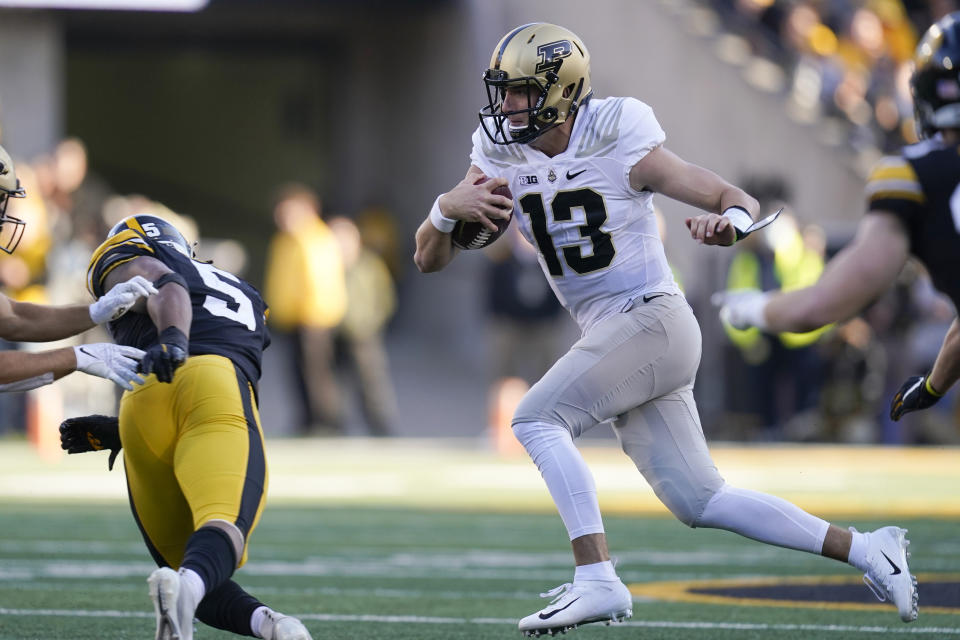 Purdue quarterback Jack Plummer (13) scrambles up field ahead of Iowa linebacker Jestin Jacobs (5) during the second half of an NCAA college football game, Saturday, Oct. 16, 2021, in Iowa City, Iowa. Purdue won 24-7. (AP Photo/Charlie Neibergall)