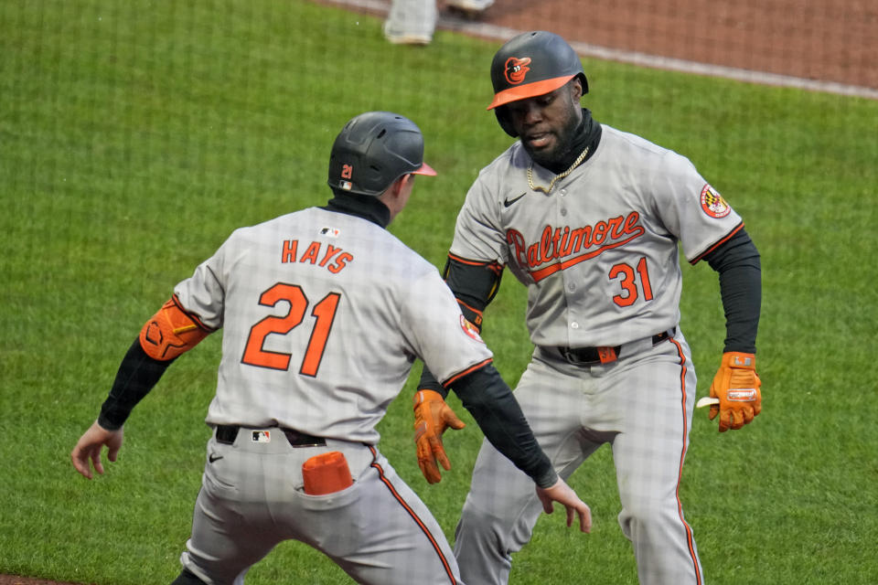 Baltimore Orioles' Cedric Mullins (31) celebrates with Austin Hays as he returns to the dugout after hitting a solo home run off Pittsburgh Pirates relief pitcher Hunter Stratton during the eighth inning of a baseball game in Pittsburgh, Friday, April 5, 2024. (AP Photo/Gene J. Puskar)