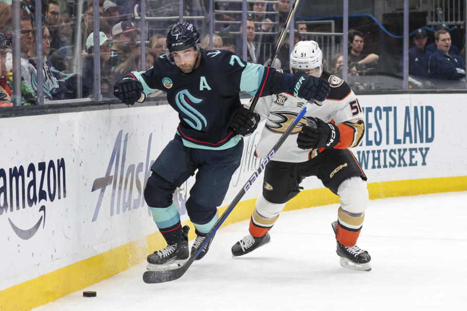 Seattle Kraken right wing Jordan Eberle (7) and Anaheim Ducks defenseman Olen Zellweger (51) go for the puck during the first period of an NHL hockey game Tuesday, March 26, 2024, in Seattle. (AP Photo/Jason Redmond)