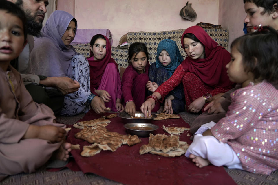 An Afghan family eat lunch in their home in one of Kabul's poor neighbourhoods in Kabul, Afghanistan Saturday, May 21, 2022. Some 1.1 million Afghan children under the age of five will face malnutrition by the end of the year. , as hospitals wards are already packed with sick children . (AP Photo/Ebrahim Noroozi)