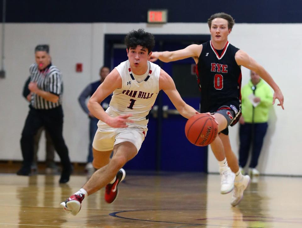 Byram Hills Chris Amenedo (1) drives to the basket in front of Rye's Quinn Monaghan (0) during boys basketball action at Byram Hills High School in Armonk Jan. 26, 2024. Byram Hills won the game 66-53.