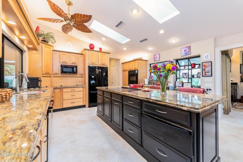 The gracious chef-inspired kitchen offers stone countertops, hand-crafted, solid-wood cabinetry and a pass-through service window to the screened veranda.