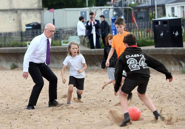 SNP leader John Swinney enjoying a game of football with some local children at Portobello Beach