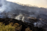 Ash and debris after an eruption of a volcano near El Paso on the island of La Palma in the Canaries, Spain, Tuesday, Sept. 21, 2021. A dormant volcano on a small Spanish island in the Atlantic Ocean erupted on Sunday, forcing the evacuation of thousands of people. Huge plumes of black-and-white smoke shot out from a volcanic ridge where scientists had been monitoring the accumulation of molten lava below the surface. (AP Photo/Emilio Morenatti)