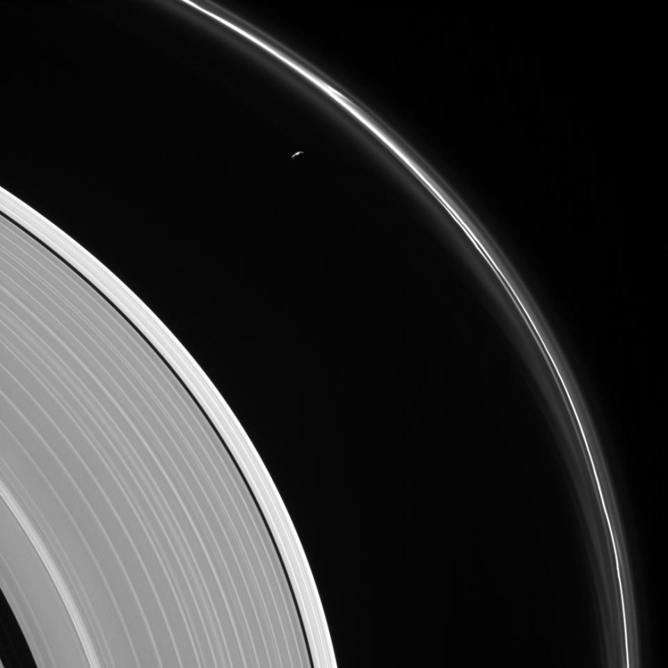 <p>The thin sliver of Saturn’s moon Prometheus lurks near ghostly structures in Saturn’s narrow F ring in this view from NASA’s Cassini spacecraft on May 13, 2017. Many of the narrow ring’s faint and wispy features result from its gravitational interactions with Prometheus (86 kilometers, or 53 miles across). (Photo: NASA/JPL-Caltech/Space Science Institute) </p>