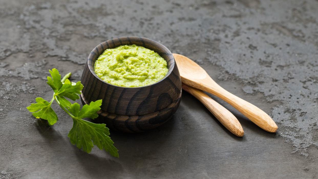light appetizer, green horseradish wasabi in a wooden saucepan dark gray background rustic style