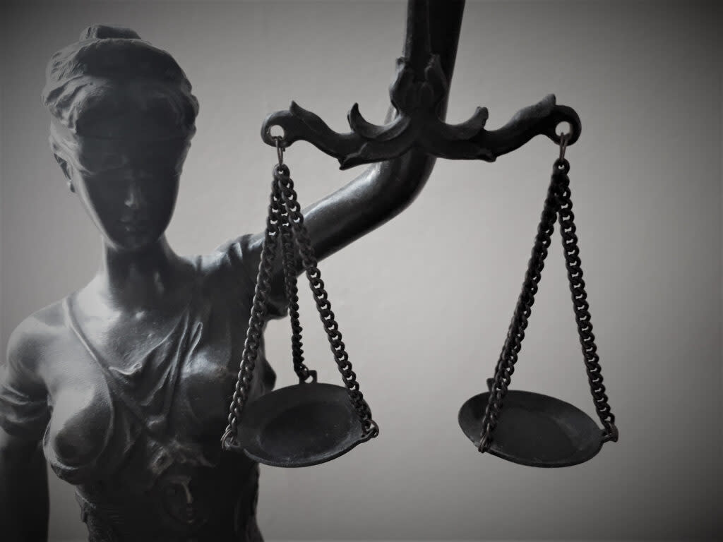 Blind figure of Justice holding scales | Getty Images Creative