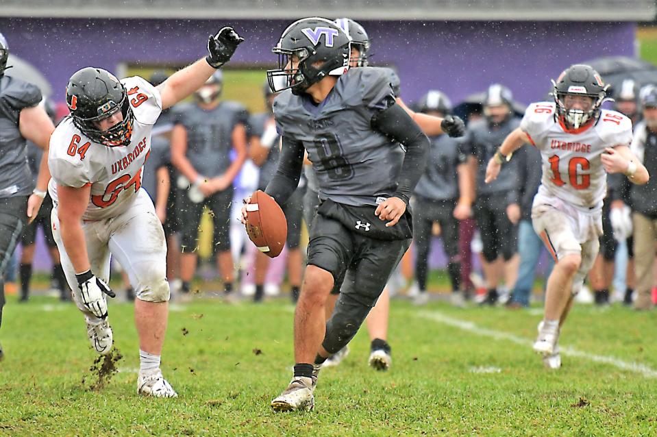 Blackstone Valley Tech quarterback Alexander Burgos looks to escape from Uxbridge defenders Chase Henault, left, and Grady Walsh.